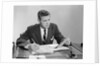 Businessman at desk looking over files papers making notes with pencil by Anonymous