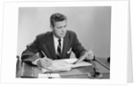 Businessman at desk looking over files papers making notes with pencil by Anonymous