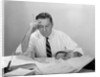 Businessman desk full papers hand to forehead serious expression by Anonymous