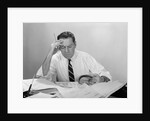 Businessman desk full papers hand to forehead serious expression by Anonymous