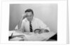 Businessman desk full papers hand to forehead serious expression by Anonymous