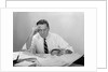 Businessman desk full papers hand to forehead serious expression by Anonymous