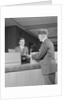 Businessman making a deposit into savings account with bank teller by Anonymous