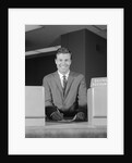Smiling man bank teller savings accounts sign on counter by Anonymous