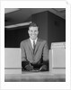 Smiling man bank teller savings accounts sign on counter by Anonymous