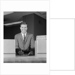 Smiling man bank teller savings accounts sign on counter by Anonymous