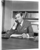 Businessman executive at desk talking on telephone by Anonymous
