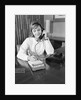 Secretary receptionist talking on telephone writing into desk calendar by Anonymous