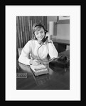 Secretary receptionist talking on telephone writing into desk calendar by Anonymous