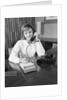 Secretary receptionist talking on telephone writing into desk calendar by Anonymous
