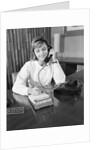 Secretary receptionist talking on telephone writing into desk calendar by Anonymous
