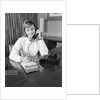 Secretary receptionist talking on telephone writing into desk calendar by Anonymous