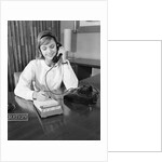 Secretary receptionist talking on telephone writing into desk calendar by Anonymous