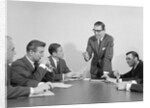 5 executive businessmen meeting at conference table one man standing by Anonymous