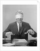 Business man hands hovering over desk wearing blindfold by Anonymous