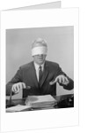 Business man hands hovering over desk wearing blindfold by Anonymous
