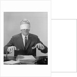 Business man hands hovering over desk wearing blindfold by Anonymous