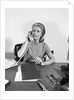 Blond businesswoman talking on telephone sitting at desk by Anonymous