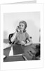 Blond businesswoman talking on telephone sitting at desk by Anonymous