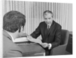 Man from behind meeting at desk of older businessman by Anonymous