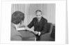 Man from behind meeting at desk of older businessman by Anonymous
