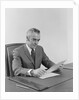 Businessman executive middle aged sitting at desk reading papers by Anonymous