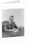 Businessman executive middle aged sitting at desk reading papers by Anonymous