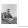 Businessman executive middle aged sitting at desk reading papers by Anonymous
