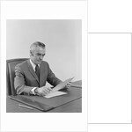 Businessman executive middle aged sitting at desk reading papers by Anonymous