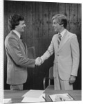 Two businessmen shaking hands handshake by Anonymous