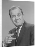 Portrait man pointing wearing suit tie smiling by Anonymous
