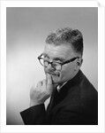 Middle aged man wearing eyeglasses low on nose quizzical facial expression by Anonymous