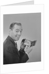 Man smiling holding wallet showing photo of family by Anonymous