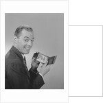 Man smiling holding wallet showing photo of family by Anonymous