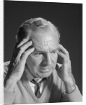 Older man with hands holding head temples by Anonymous