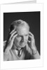 Older man with hands holding head temples by Anonymous