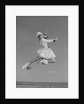 Woman majorette wearing band uniform holding baton jumping into the air by Anonymous