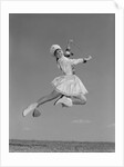 Woman majorette wearing band uniform holding baton jumping into the air by Anonymous