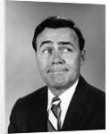 Businessman making funny face looking to the side by Anonymous