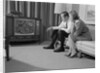 Couple man woman sitting on couch watching television by Anonymous