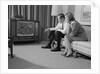 Couple man woman sitting on couch watching television by Anonymous