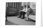 Couple man woman sitting on couch watching television by Anonymous