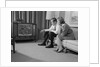 Couple man woman sitting on couch watching television by Anonymous