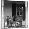 Couple man woman sitting on porch in rocking chairs holding newspapers up hiding their faces by Anonymous