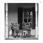 Couple man woman sitting on porch in rocking chairs holding newspapers up hiding their faces by Anonymous