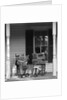 Couple man woman sitting on porch in rocking chairs holding newspapers up hiding their faces by Anonymous