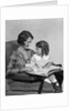 Mother & daughter smiling sitting in chair reading book by Anonymous