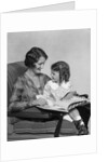 Mother & daughter smiling sitting in chair reading book by Anonymous