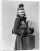 Smiling young blond woman wearing hat fur trimmed coat carrying packages by Anonymous