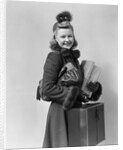 Smiling young blond woman wearing hat fur trimmed coat carrying packages by Anonymous